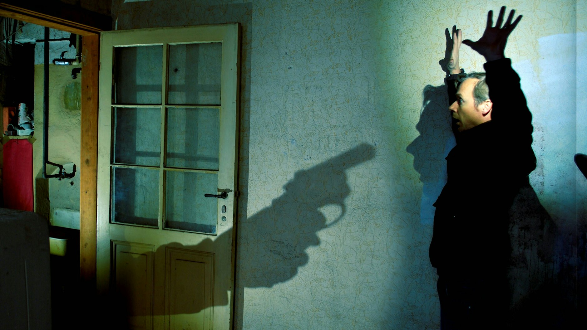 Ein Mieter wird von einem Räuber mit einer Pistole bedroht (Symbolbild).