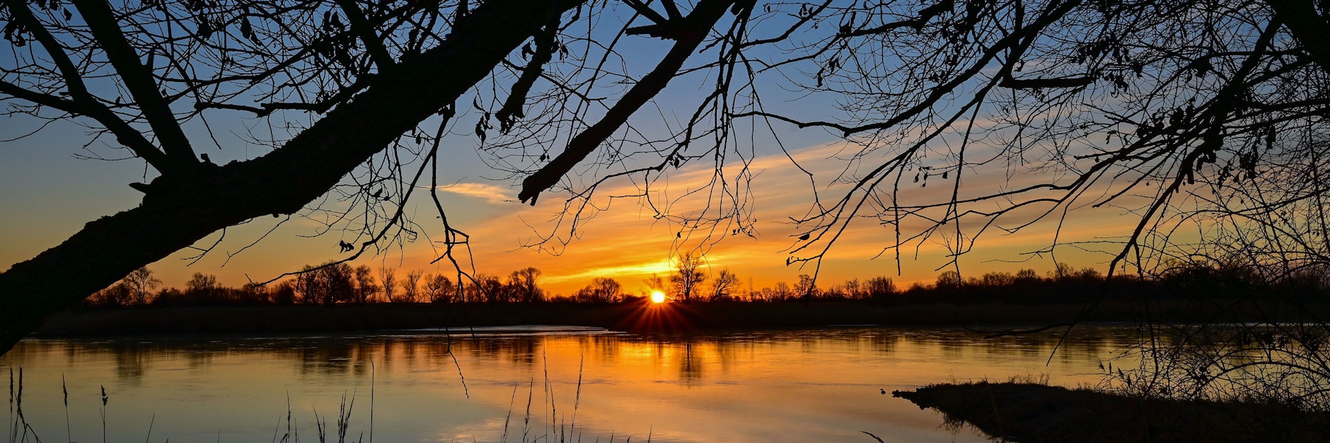 Farbenprächtig leuchtet der Sonnenaufgang über dem deutsch-polnischen Grenzfluss Oder.