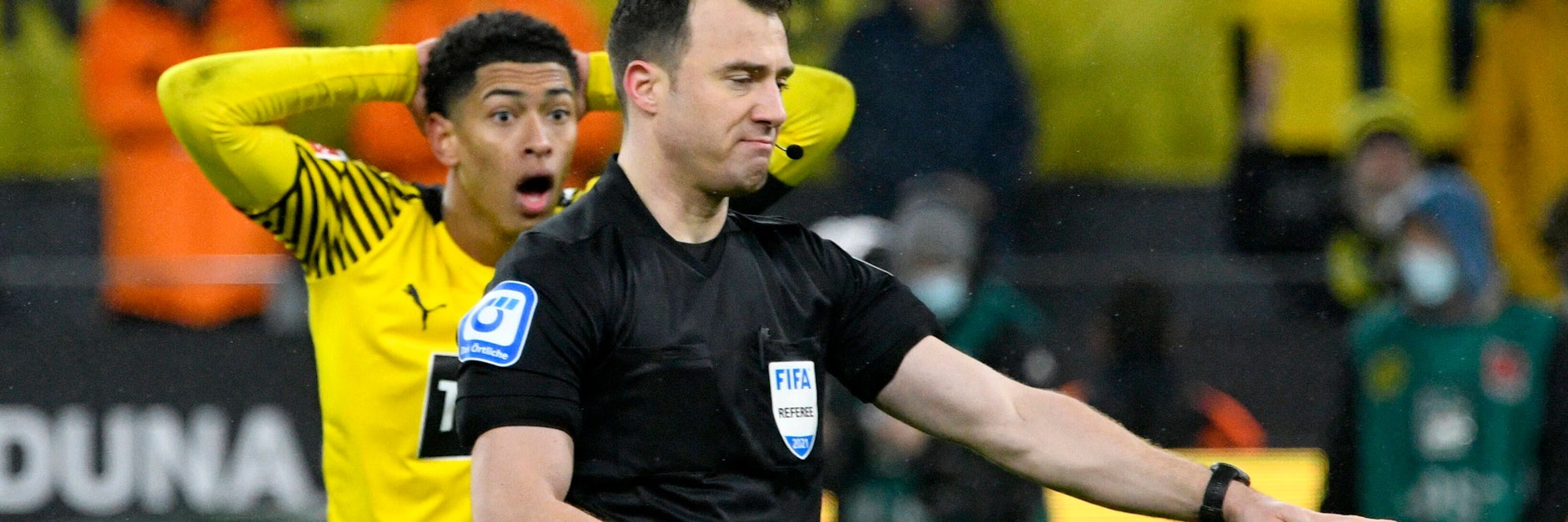 Schiri Felix Zwayer zeigt auf den Elfmeterpunkt. Dortmunds Jude Bellingham kann es nicht fassen. Der BVB verlor deswegen 2:3 gegen Bayern.&nbsp;