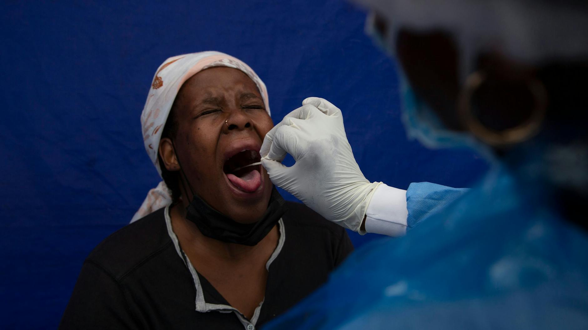 Soweto: Einer Patientin wird ein Rachenabstrich entnommen, um sie in einer Einrichtung auf Covid-19 zu testen. Die Regierung in Südafrika sieht den Höhepunkt der Omikron-Welle überschritten.