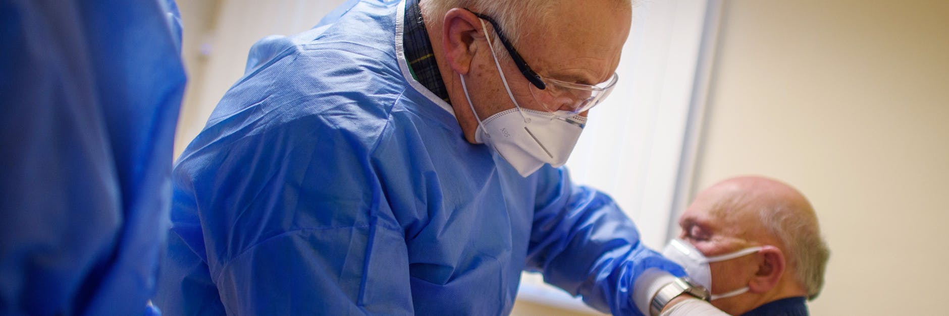 Ein Arzt impft im Impfzentrum des Landkreises Stendal einen Mann gegen Corona. Dorthin sind auch Berliner gereist, um sich die Spritze gegen das Virus zu holen. 