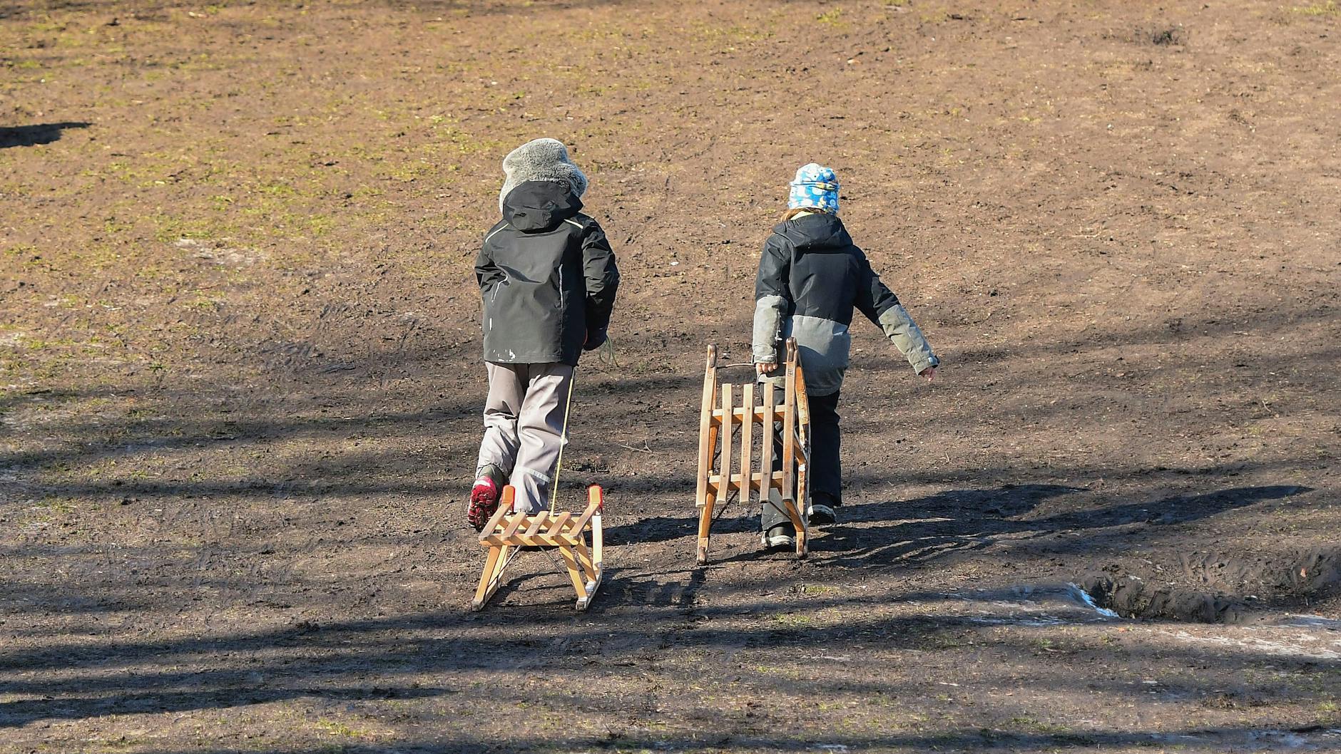 Einige kleine Rodel-Fans lassen sich von der Schlammpiste nicht bremsen.<br>
