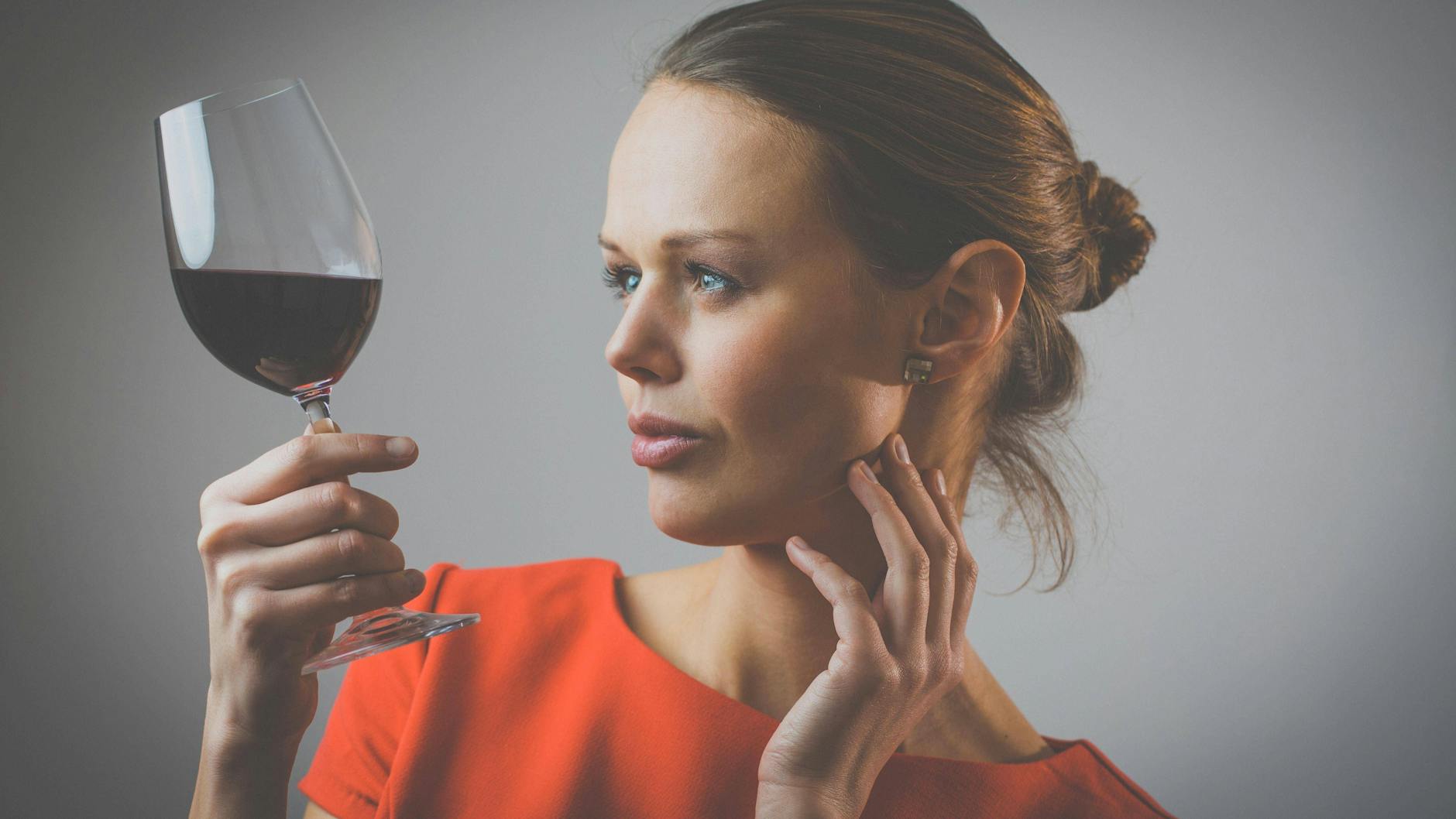 Eine Frau hält ein Glas Rotwein in der Hand. (Symbolbild)