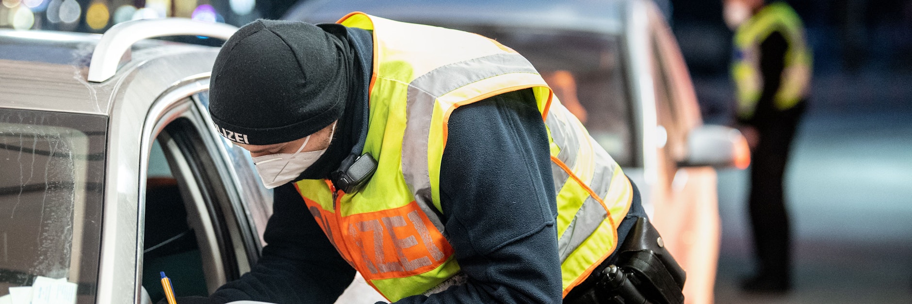 Ein Bundespolizist kontrolliert aus Österreich kommende Menschen in ihren Autos.