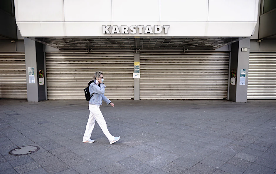 Eine Passantin mit Mund-Nasenschutz geht am Mittag am Kurfürstendamm an einer geschlossenen Karstadt-Filiale vorbei.&nbsp;