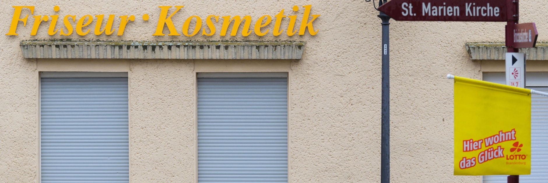 Die Rollläden vor den Fenstern eines Friseur- und Kosmetiksalons in der Innenstadt von Bad Belzig sind heruntergelassen.