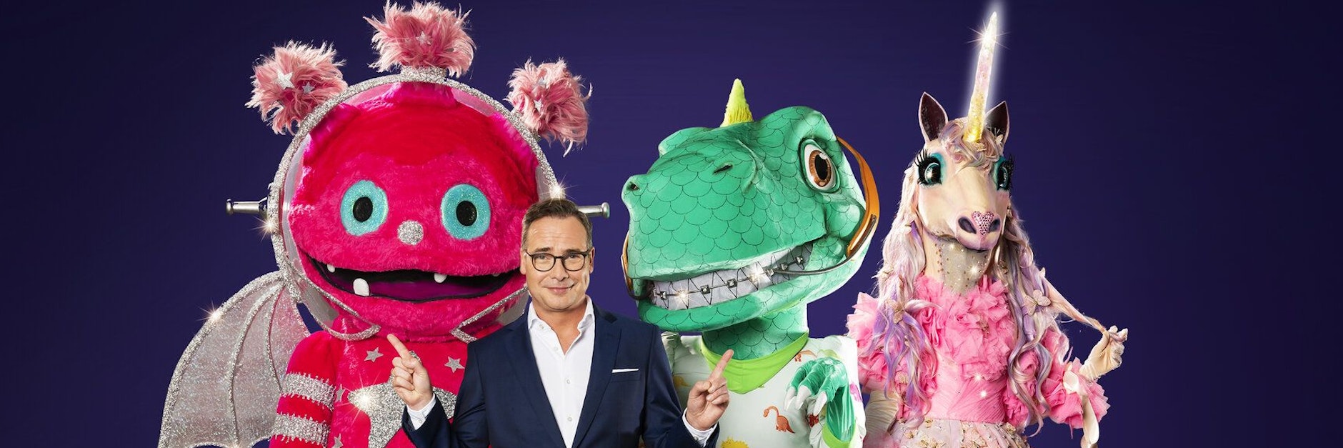 Moderator Matthias Opdenhövel mit Monstronaut (l.), Dinosaurier und Einhorn.