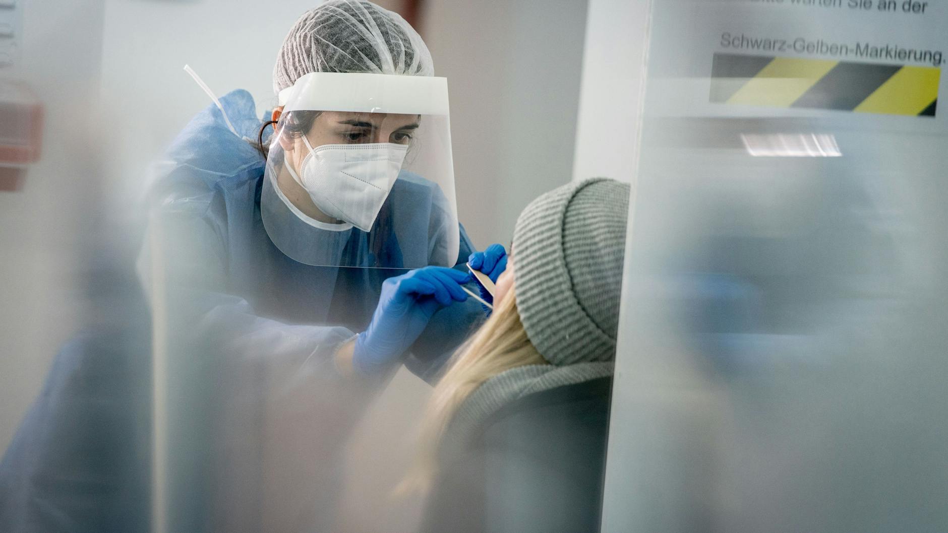 Medizinisch geschultes Personal nimmt in einer Galerie in Berlin-Mitte einen Mund- und Nasenabstrich für einen Corona-Schnelltest.