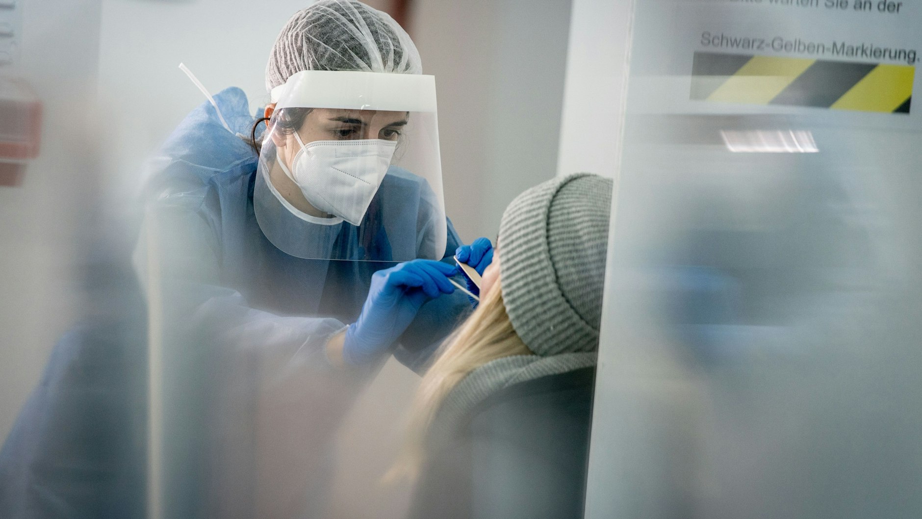 Medizinisch geschultes Personal nimmt in einer Galerie in Berlin-Mitte einen Mund- und Nasenabstrich für einen Corona-Schnelltest.