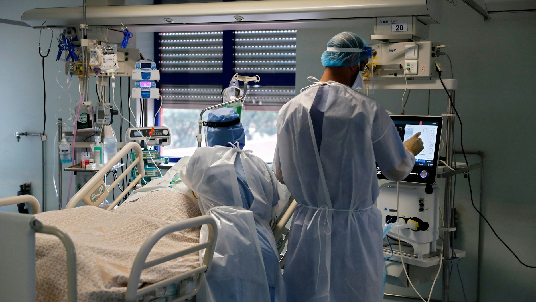 Eine Krankenschwester und ein Arzt kümmern sich um einen Patienten auf der Corona-Intensivstation.