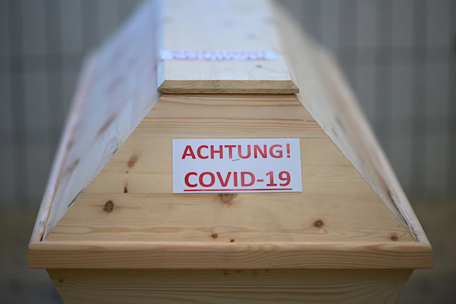 Ein Sarg mit der Aufschrift „Achtung! Covid-19“ steht in einem Krematorium (Symbolbild).