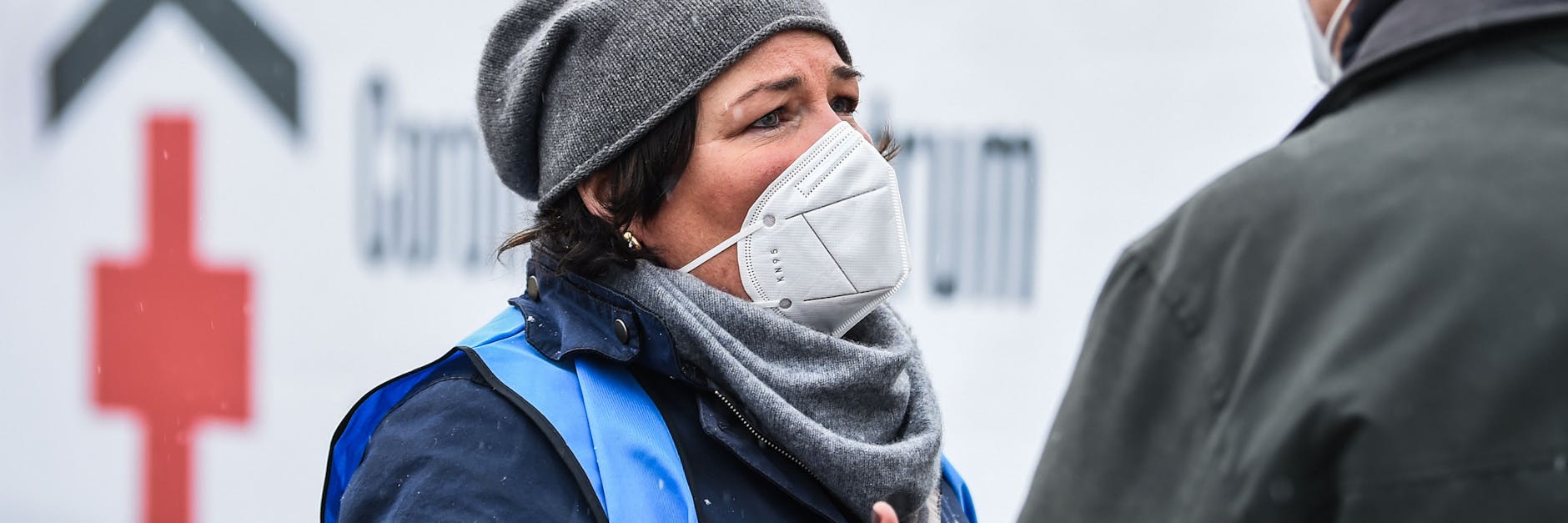 TV-Moderatorin Vera Int-Veen (l.), Fernsehmoderatorin, nimmt einen Herren, der zum Impfen gegen das Coronavirus am Erika-Heß-Eisstadion ankommt, in Empfang.