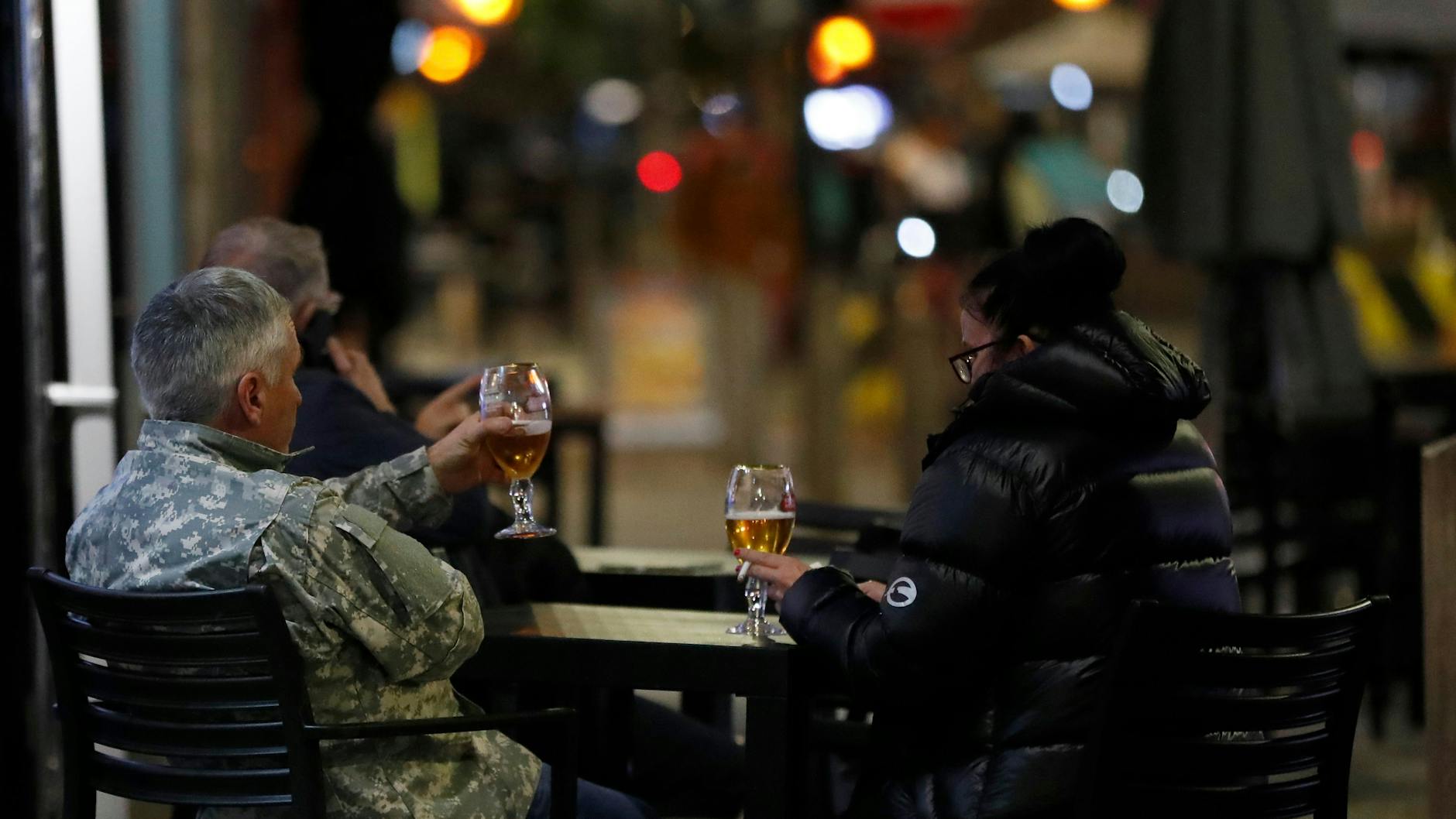 Gäste trinken vor einem Restaurant in Liverpool ein Bier. 