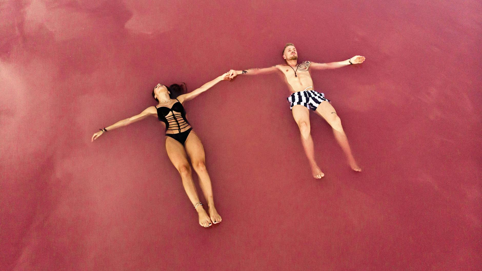 Ein Paar lässt sich im rosafarbenen Salzwasser einer Lagune im spanischen Torrevieja treiben. 