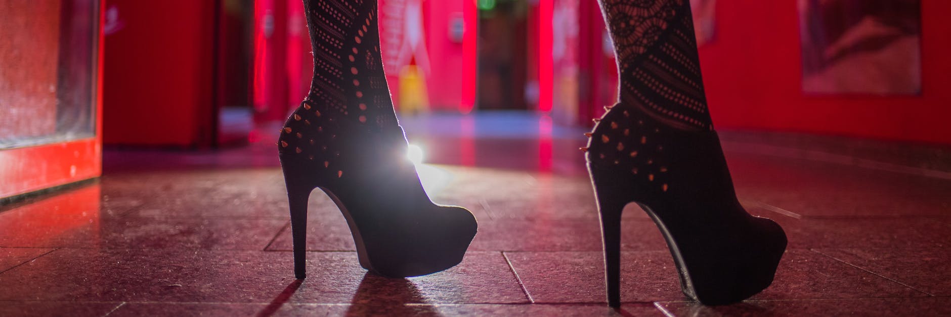 Eine Frau steht im Eingangsbereich eines Bordells. 