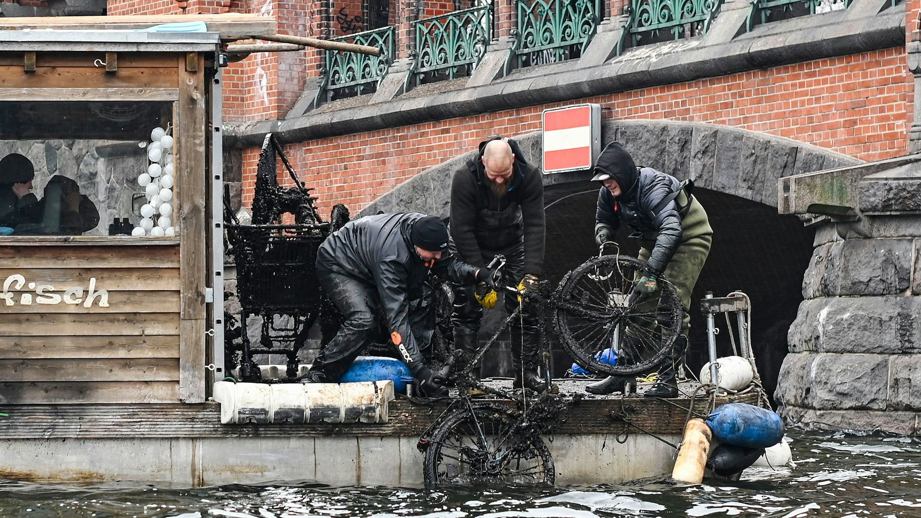 Gemeinsam ziehen die Männer ein Fahrrad nach dem anderen aus der Spree.<br>