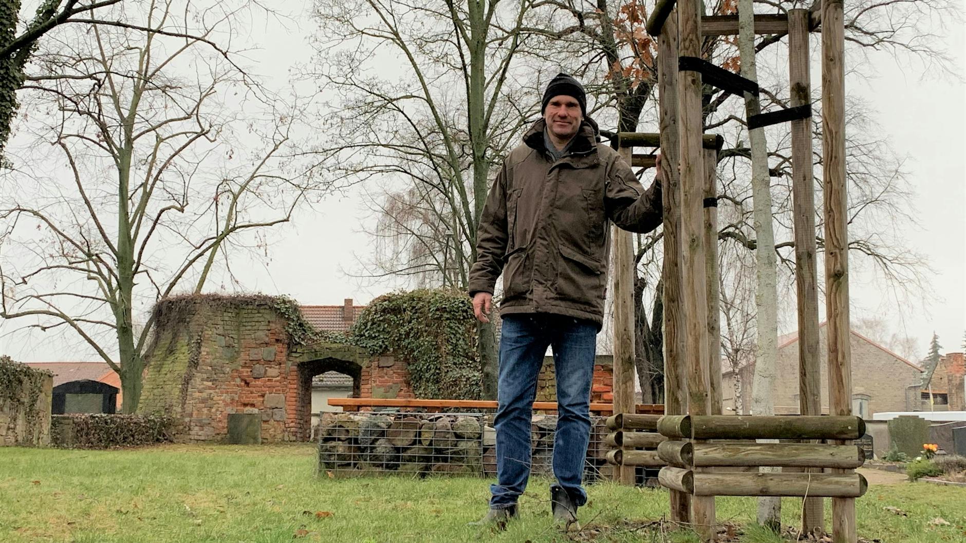 Henning Frenzel an zwei der vier Stieleichen, die im Karree stehen und die Ausmaße des gesprengten Turms zeigen.