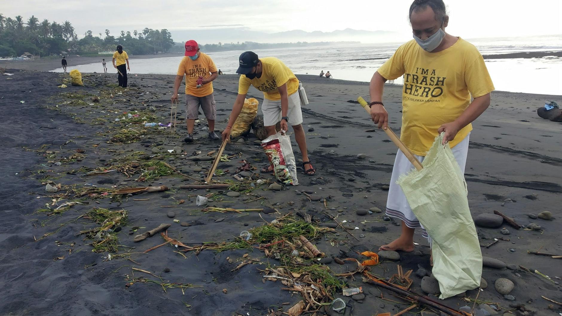 Mit Zangen und Säcken bewaffnet sind die Freiwilligen am Strand unterwegs.