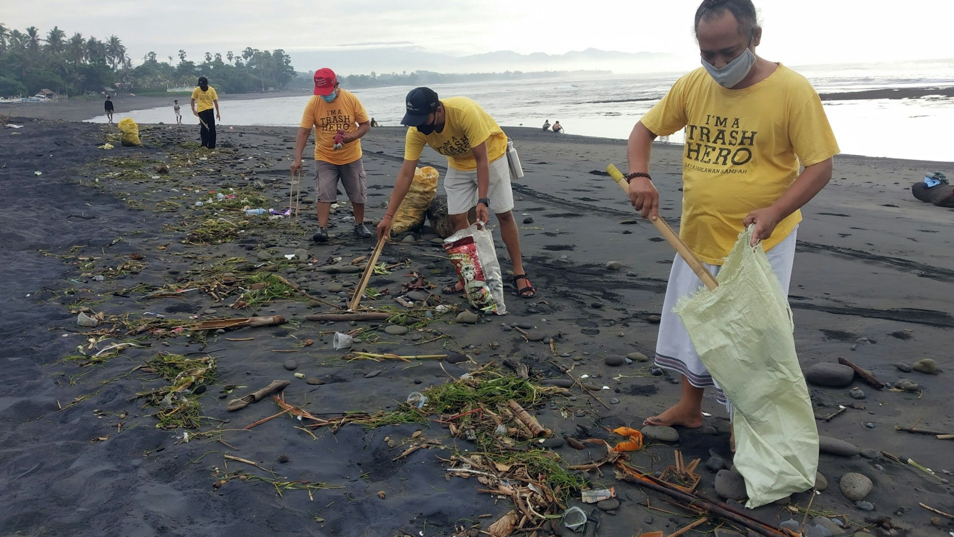 Mit Zangen und Säcken bewaffnet sind die Freiwilligen am Strand unterwegs.