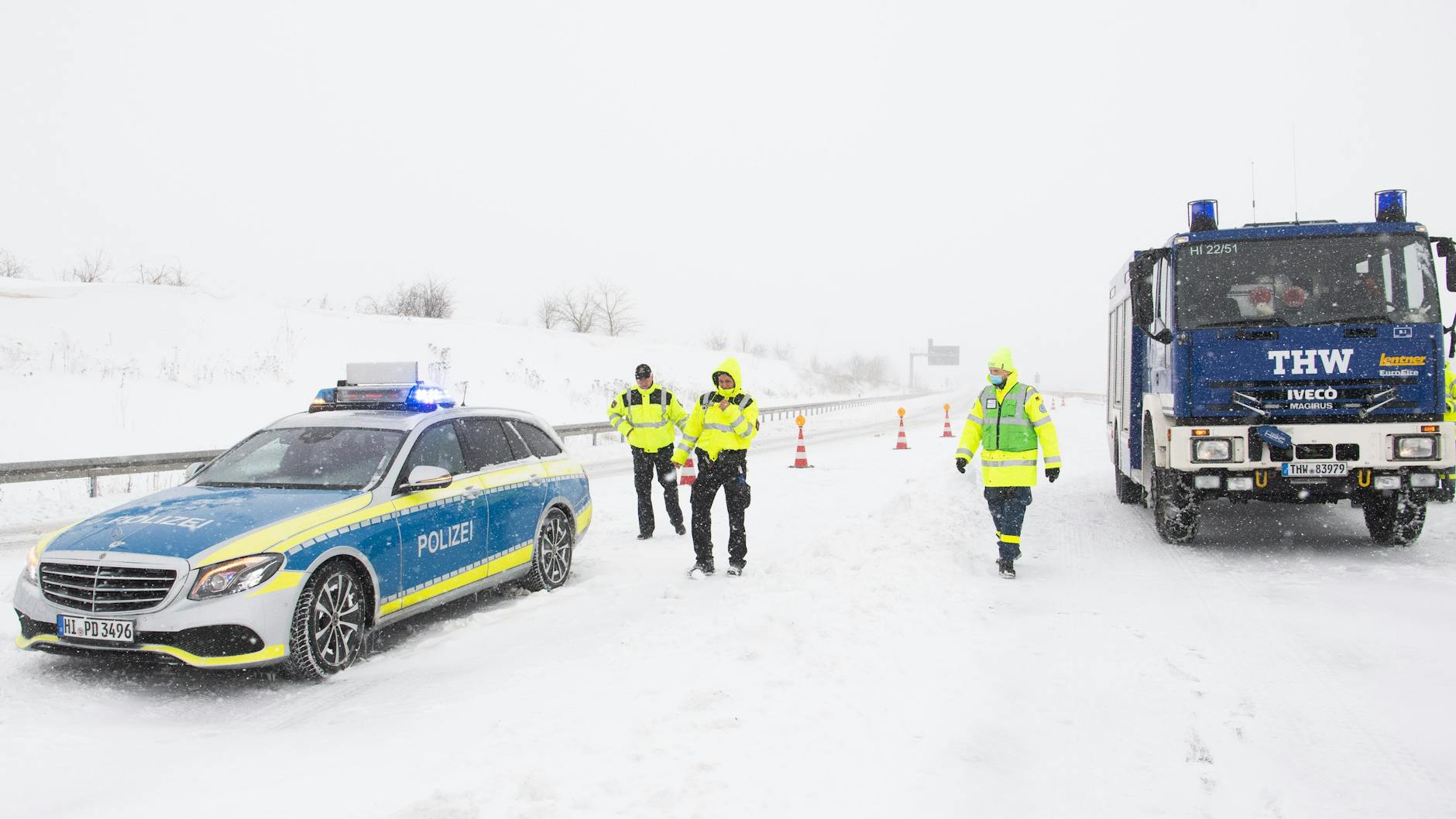 Polizei und Technisches Hilfswerk THW stehen auf der gesperrten Autobahn A7. 