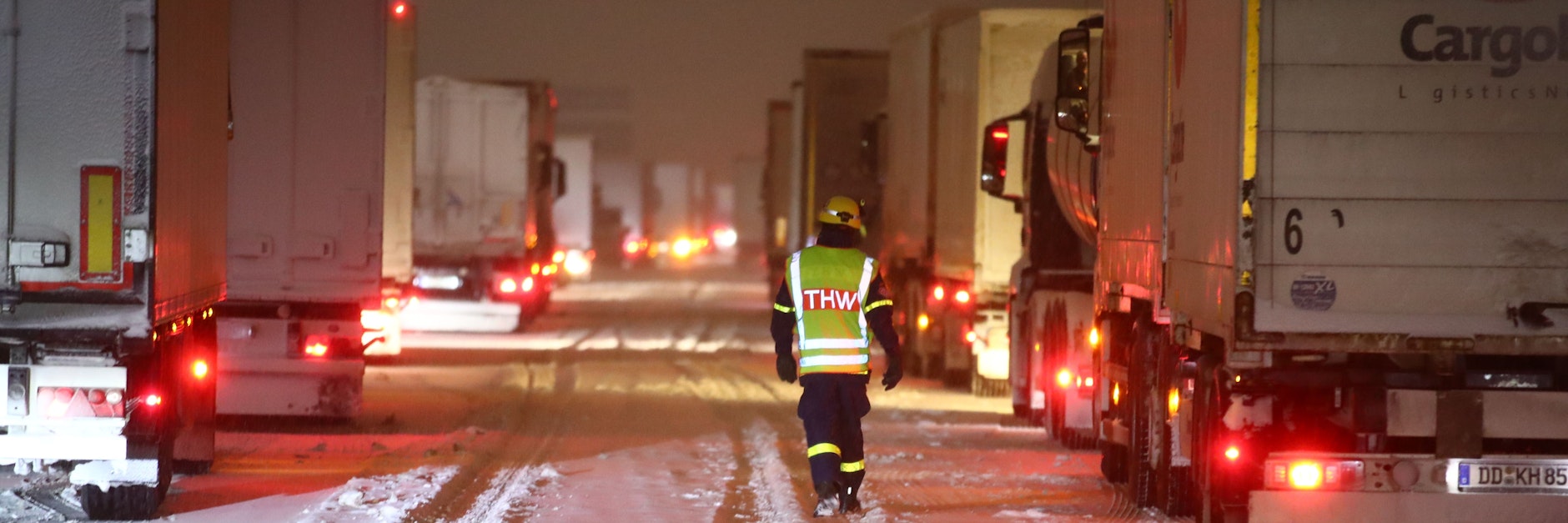 Mitarbeiter des Technischen Hilfswerks (THW) betreuen Lkw-Fahrer, die auf der Autobahn 4 bei Gera im Stau stehen.