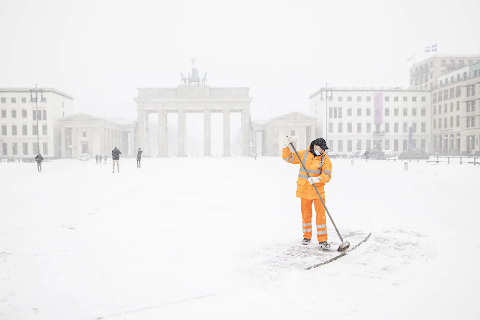 Ein Mitarbeiter der BSR schippt Schnee auf dem Paris Platz vor dem Brandenburger Tor.