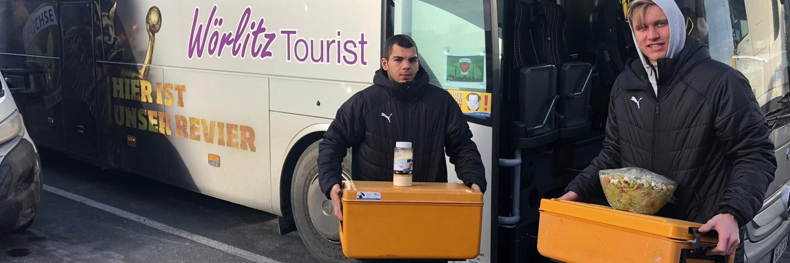 Die Füchse Tim Matthes (l.) und Marian Michalczik packen vor der Abfahrt des Busses fleißig mit an.
