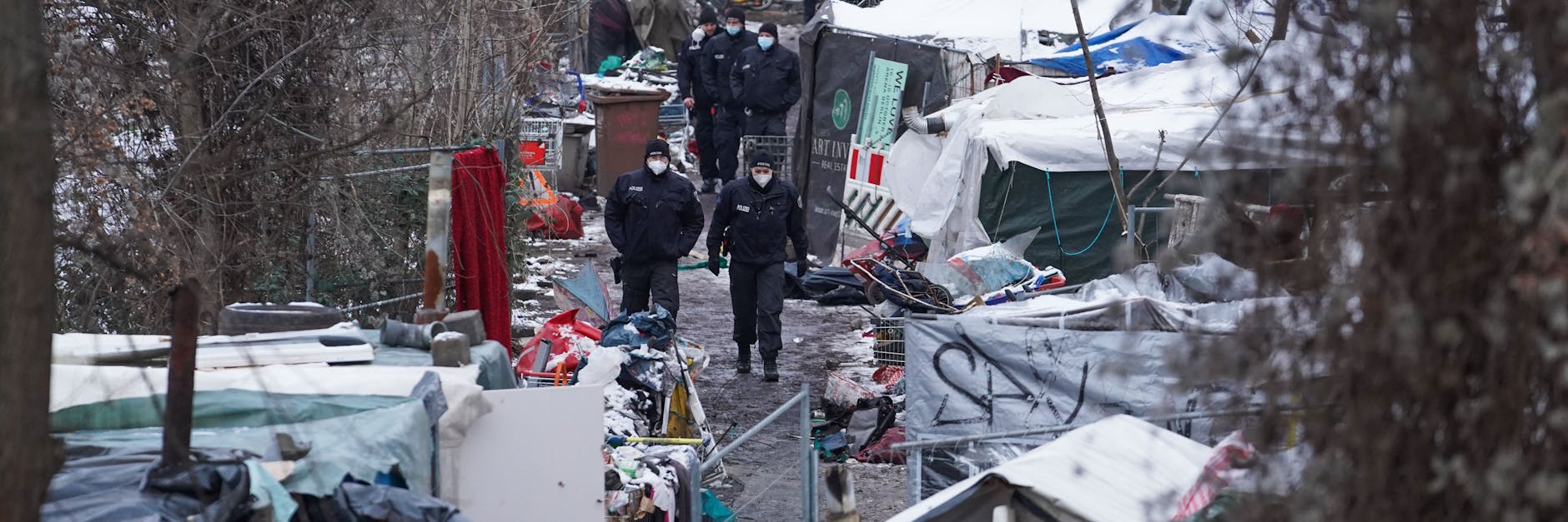 Nach der Räumung streifen Polizisten durch das Obdachlosencamp an der Rummelsburger Bucht.