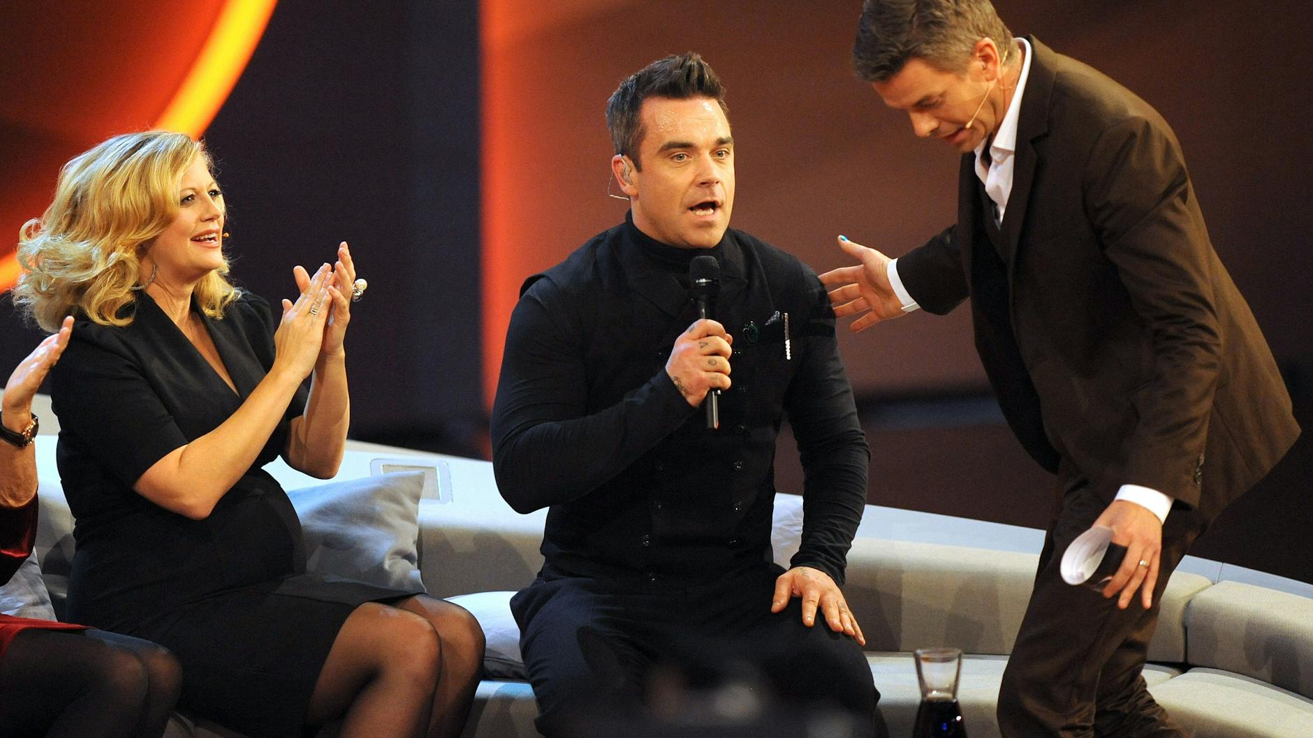Die schwangere Schauspielerin Barbara Schönberger, Entertainer Robbie Williams und Moderator Markus Lanz (r.) während einer Livesendung von „Wetten dass ..?“ im November 2012.