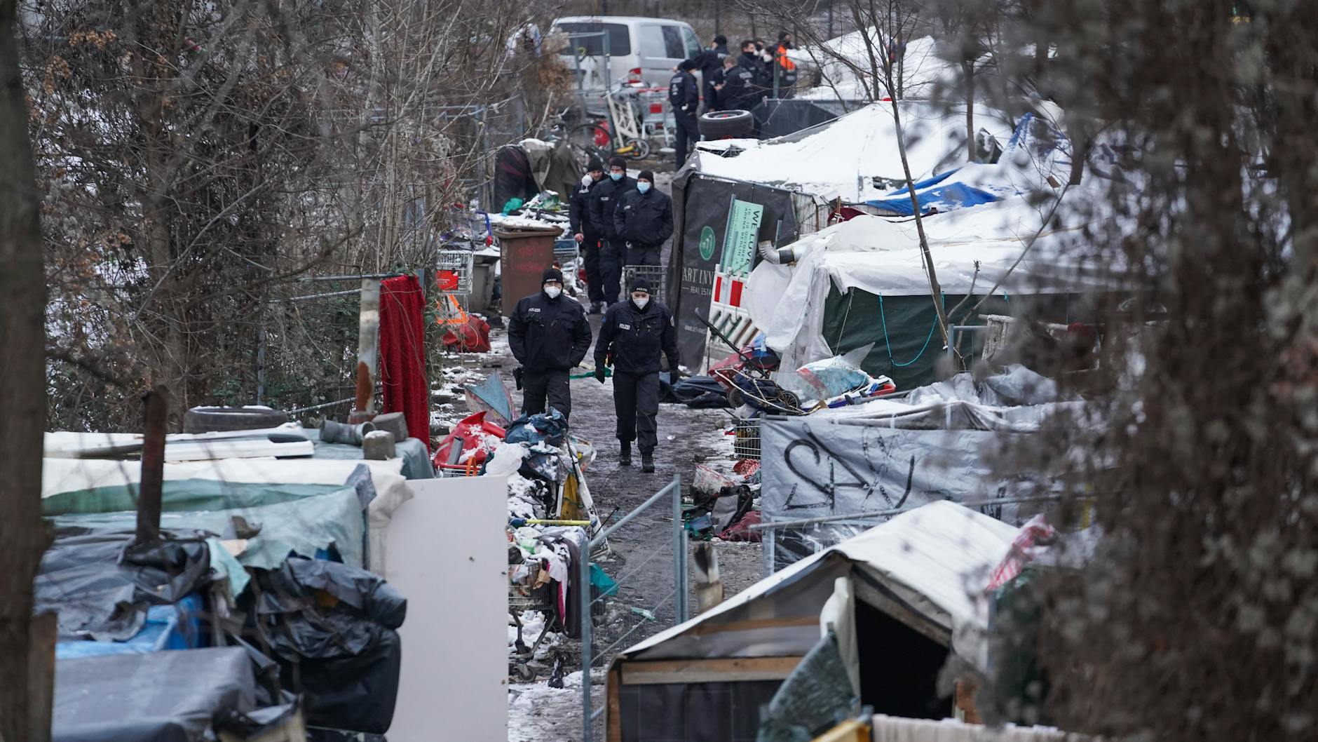 Nach der Räumung streifen Polizisten durch das Obdachlosencamp an der Rummelsburger Bucht.