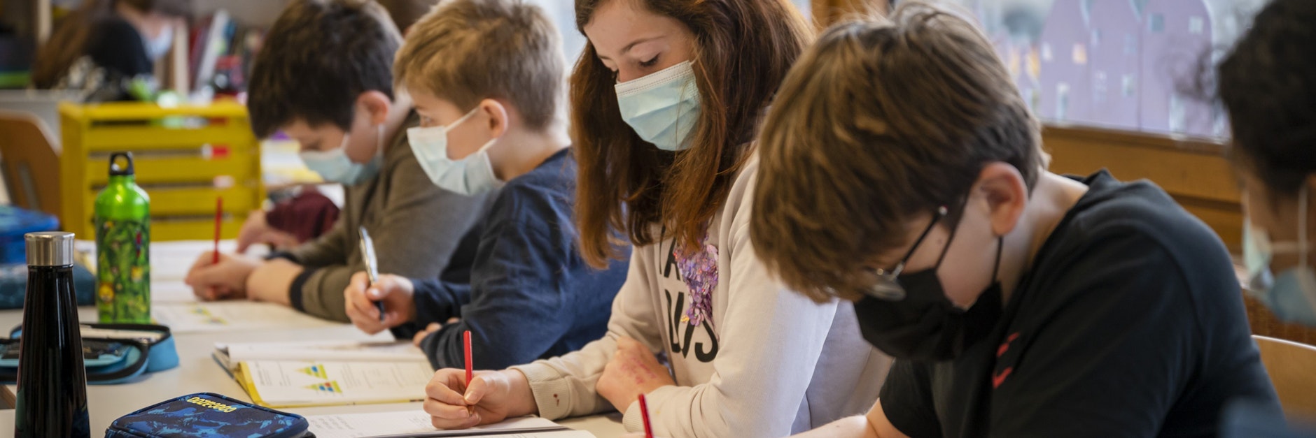 Schüler tragen im Unterricht Gesichtsmasken.