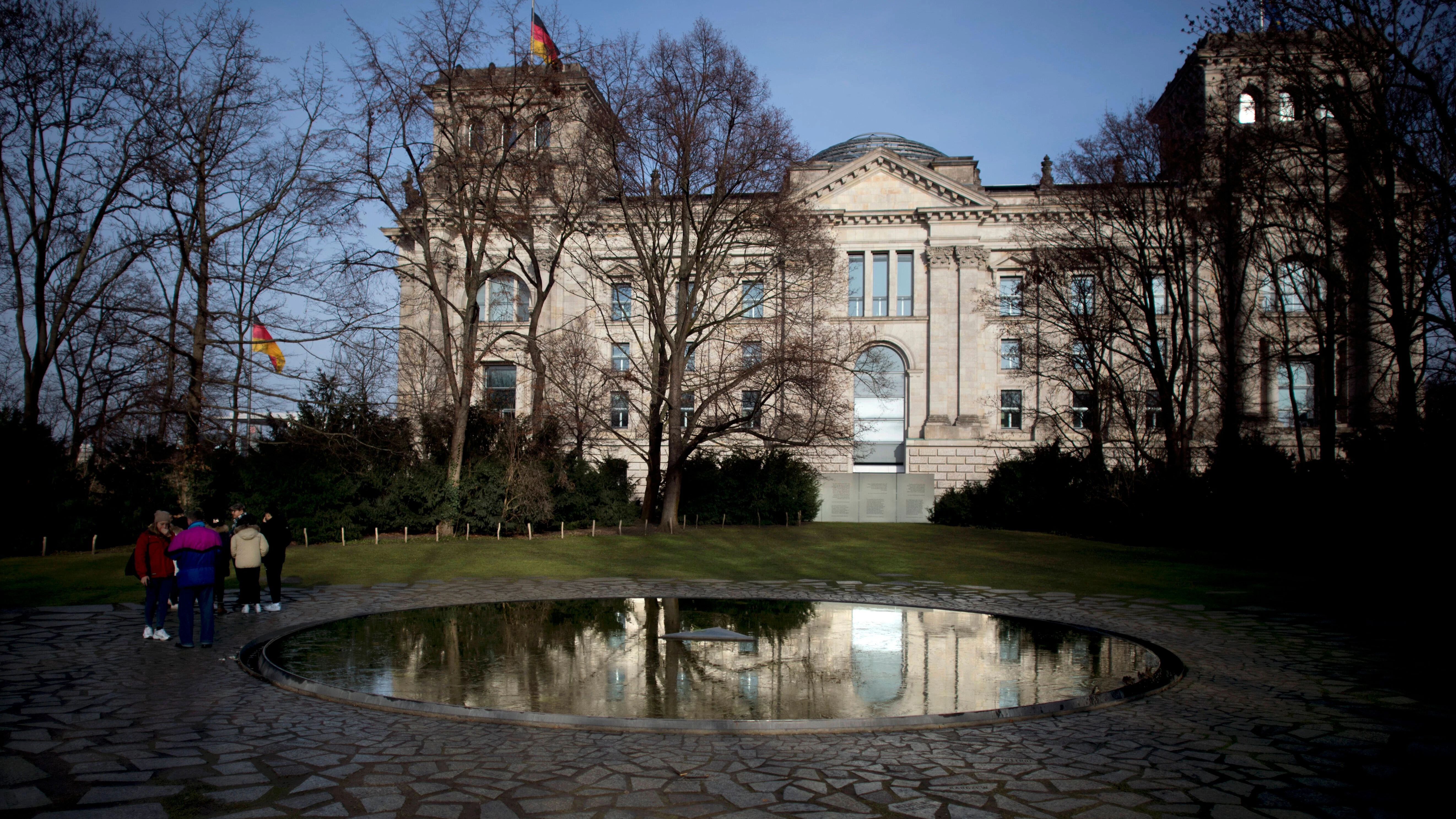 Das&nbsp;„schwarze Becken“ prägt das Denkmal. Im Hintergrund das Reichstagsgebäude, Sitz des Bundestags.