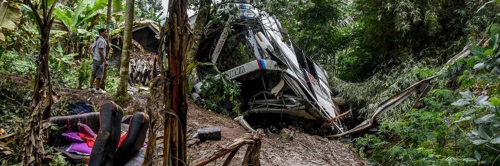 Anwohner inspizieren das Wrack eines Busses, der in Sumedang, West-Java, in eine Schlucht gestürzt ist.