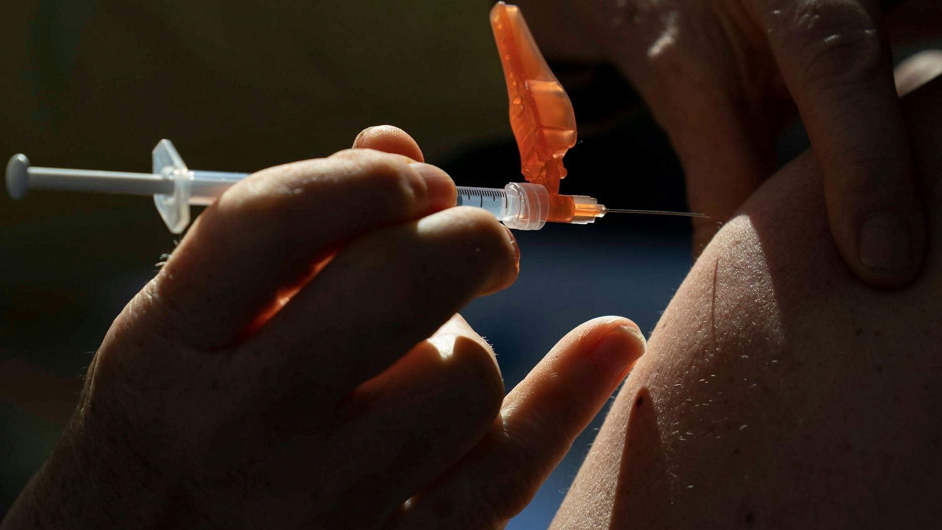 Ein Arzt verabreicht einer Patientin eine Spritze. 