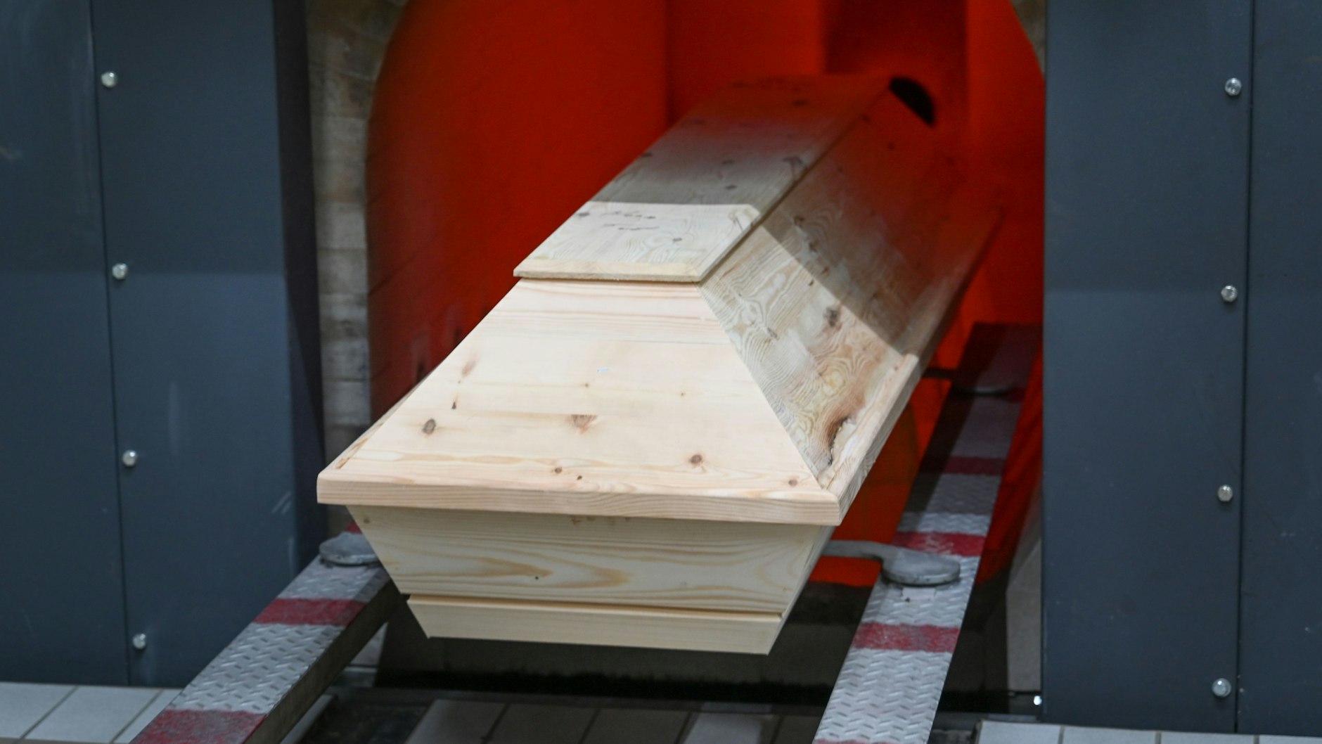 Ein Sarg wird in den Ofen des Krematorium zur Einäscherung hineingefahren.