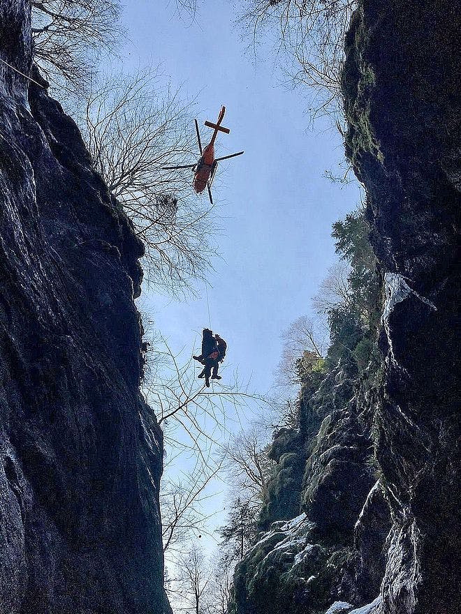 Der verunglückte 18-jährige Wanderer mit einem Retter: Durch einen Berghang werden sie in den Helikopter gezogen.