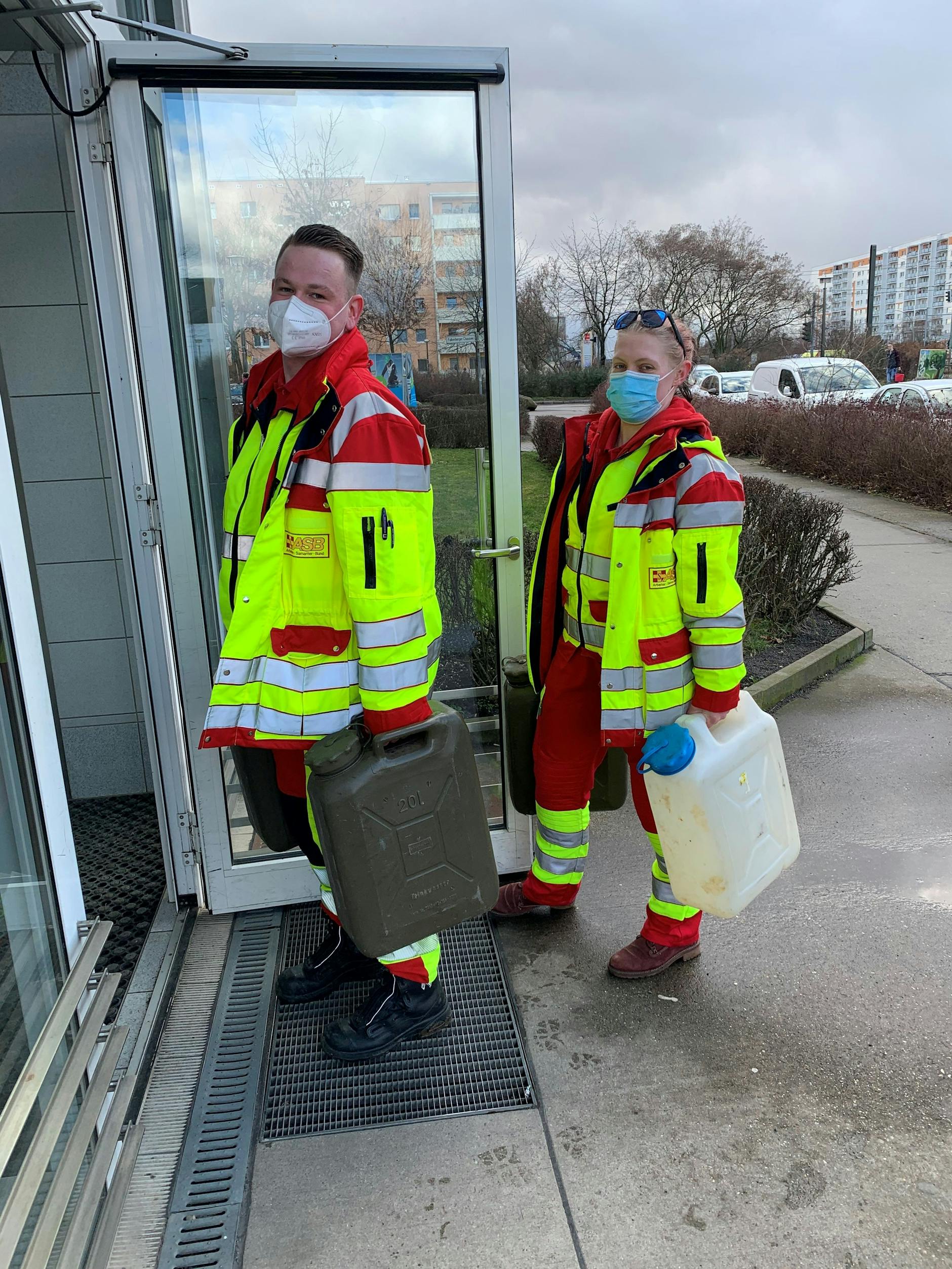 David (21) und Käthe (18), Mitarbeiter des ASB, beliefern ein Haus in der Falkenberger Chaussee mit Wasser aus den Notzapfstellen.