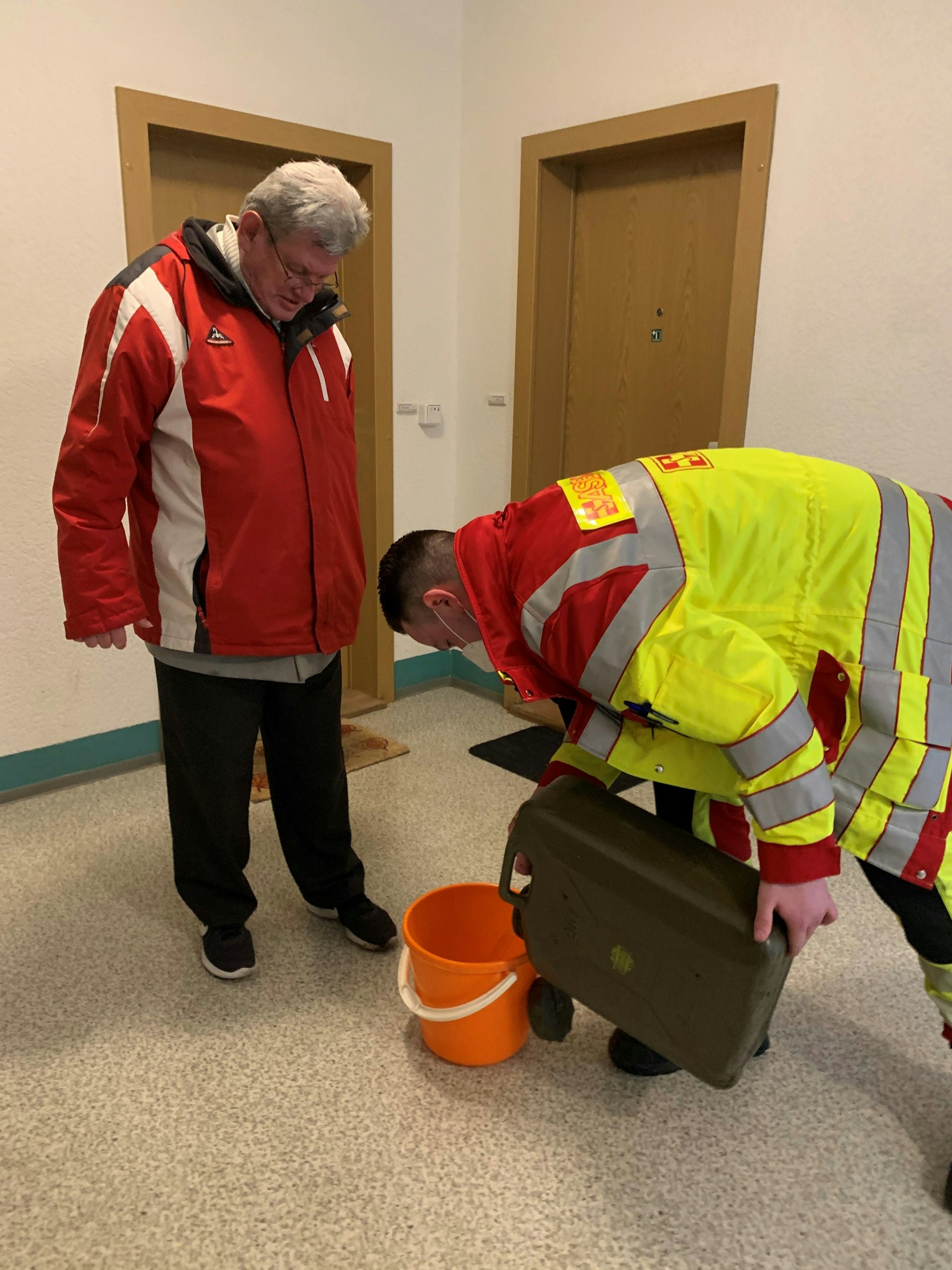 Dieter Bartling (68), Bewohner der Falkenberger Chaussee 42, bekommt Wasser von den Einsatzkräften der ASB.
