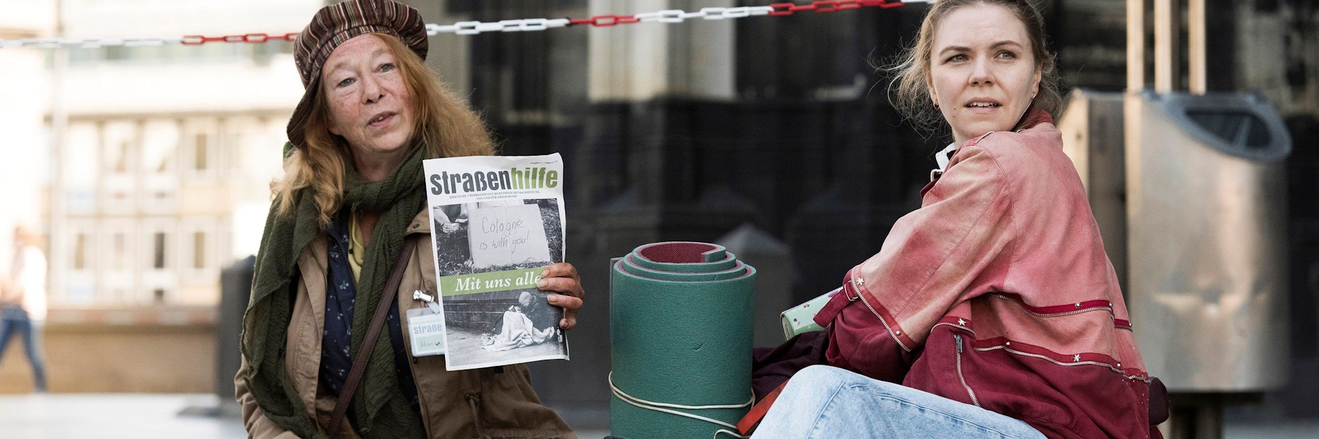 Monika Keller (Rike Eckermann, links) verkauft am Dom Obdachlosenzeitungen. Sie hilft Ella Jung (Ricarda Seifried, rechts), die gerade erst lernt, sich auf der Straße durchzuschlagen.<br><br>