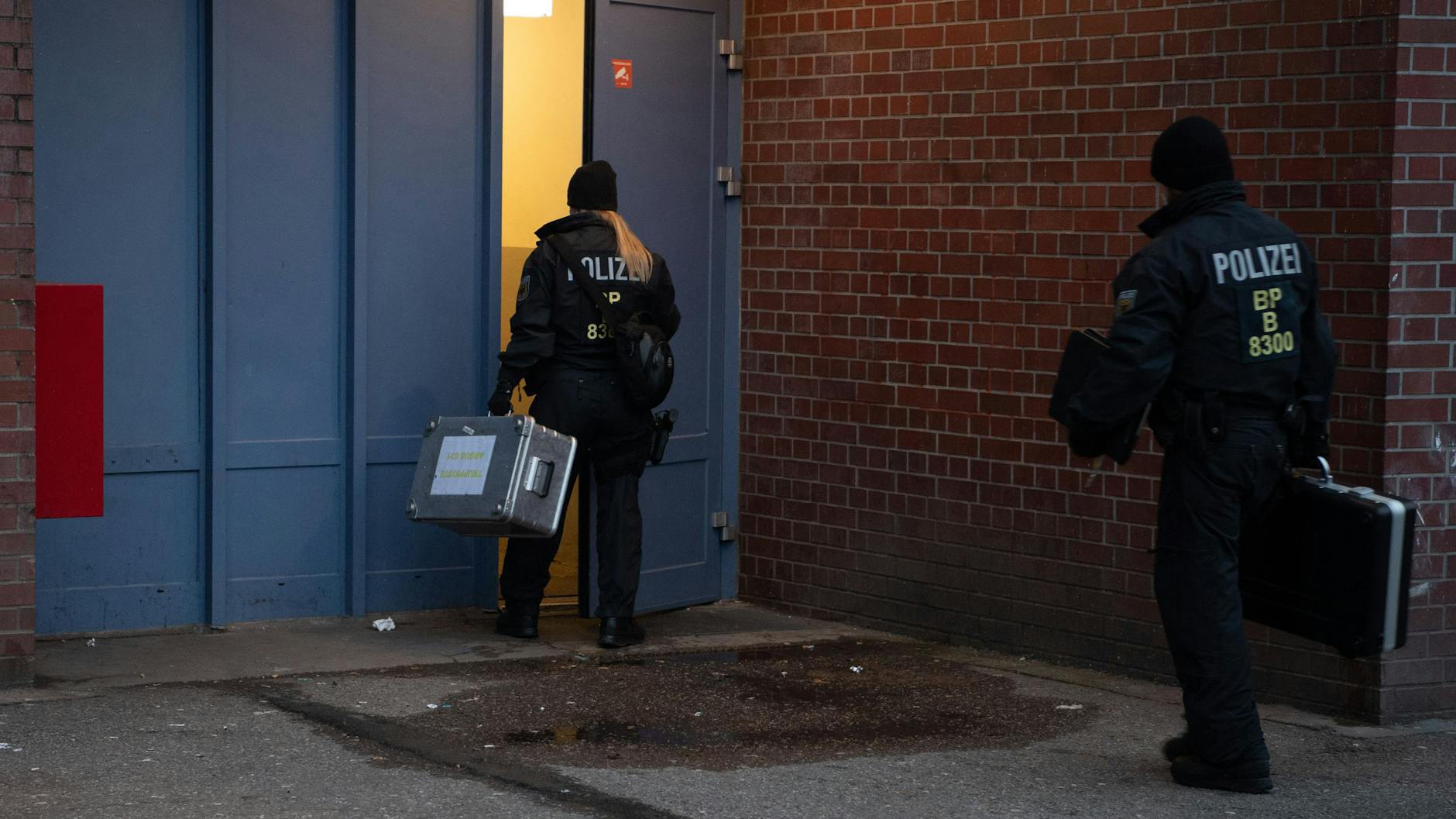 Polizisten gehen während der Razzia in Berlin-Lichtenberg in ein Wohnhaus.