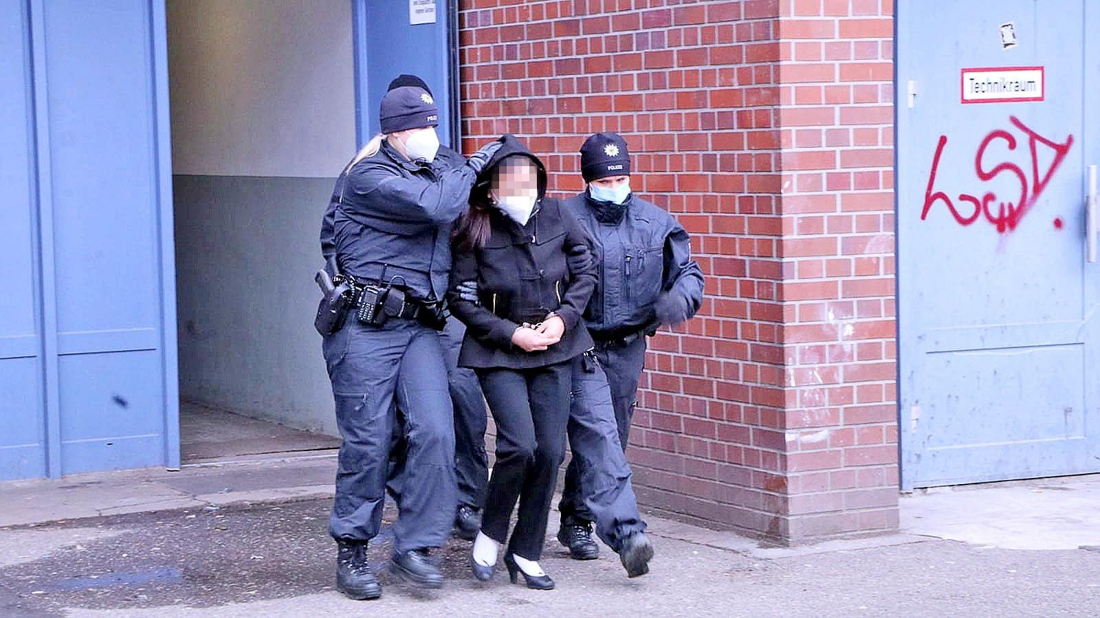 Bundespolizisten verhaften eine Verdächtige.