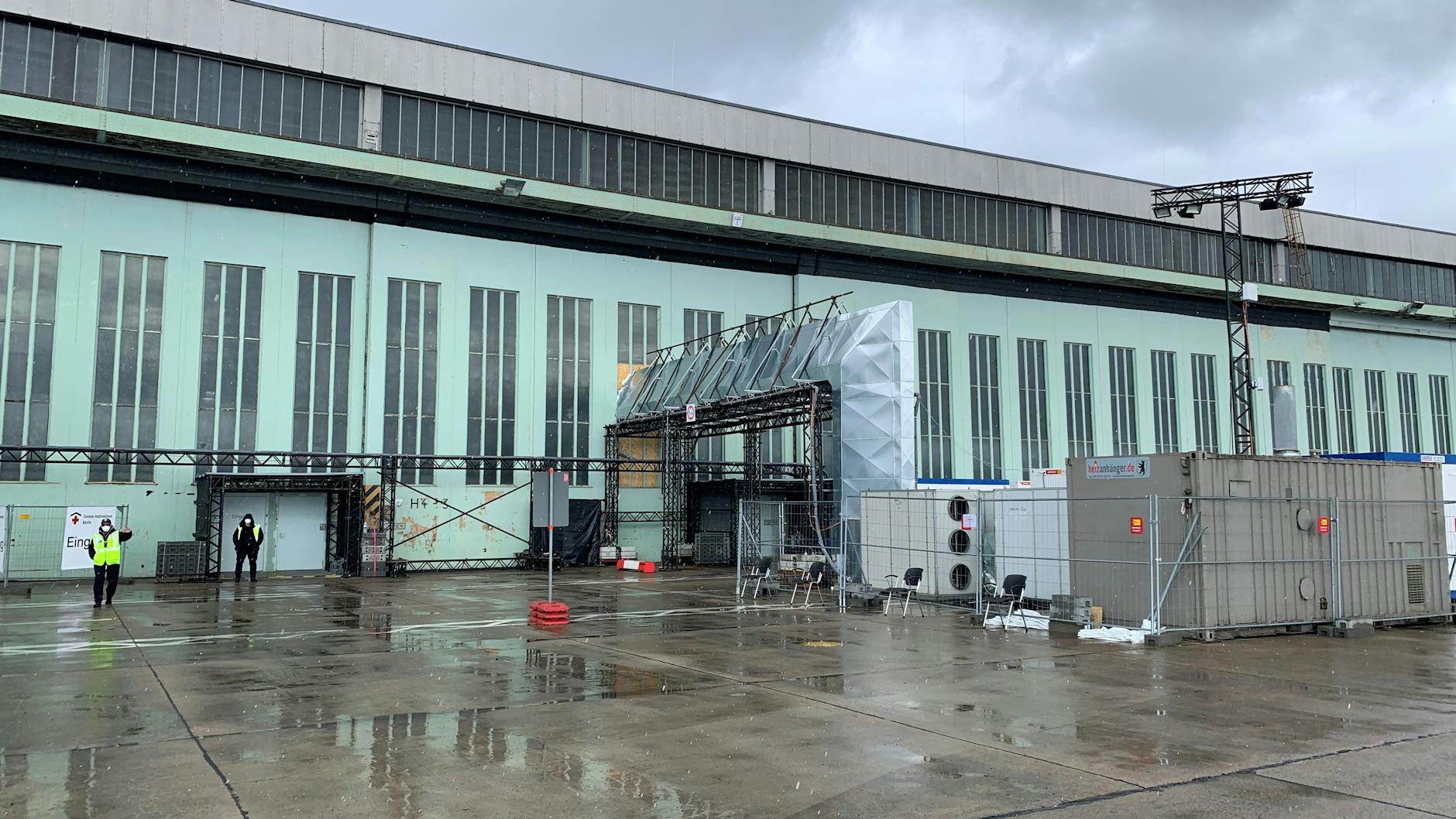 Vor dem Impf-Hangar in Tempelhof wurden große Heiz- und Belüftungsanlagen aufgestellt. Der schwarze Streifen über den Rolltoren ist der Taubenschutz.