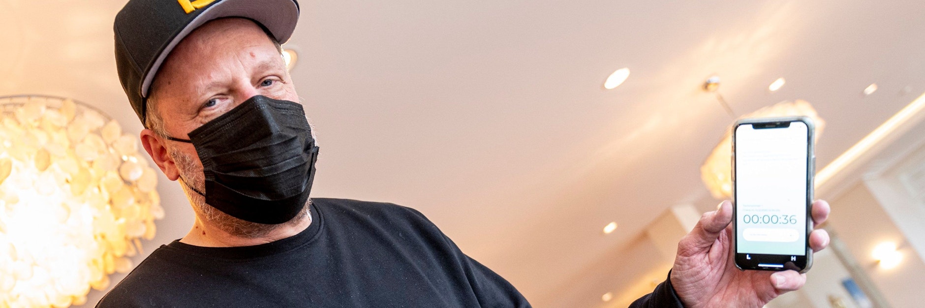 Rapper Smudo demonstriert auf seinem Smartphone die Funktionsweise der App „Luca“. 