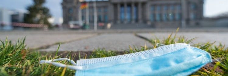 Eine Einwegmaske auf der Wiese vor dem deutschen Bundestag.