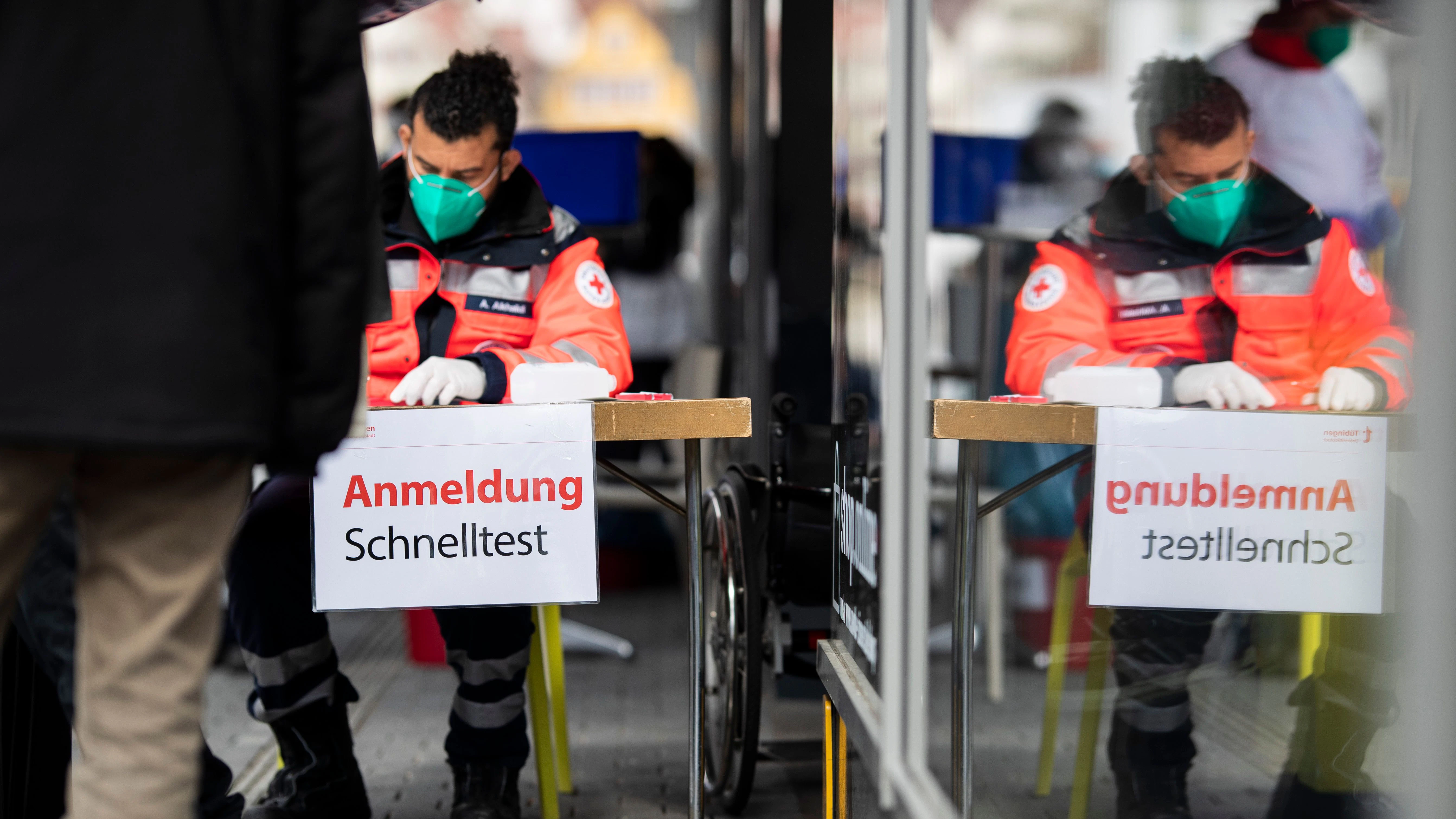 Einige Menschen stehen in einer Schlange um sich für einen Schnelltest in der Tübinger Innenstadt anzumelden.