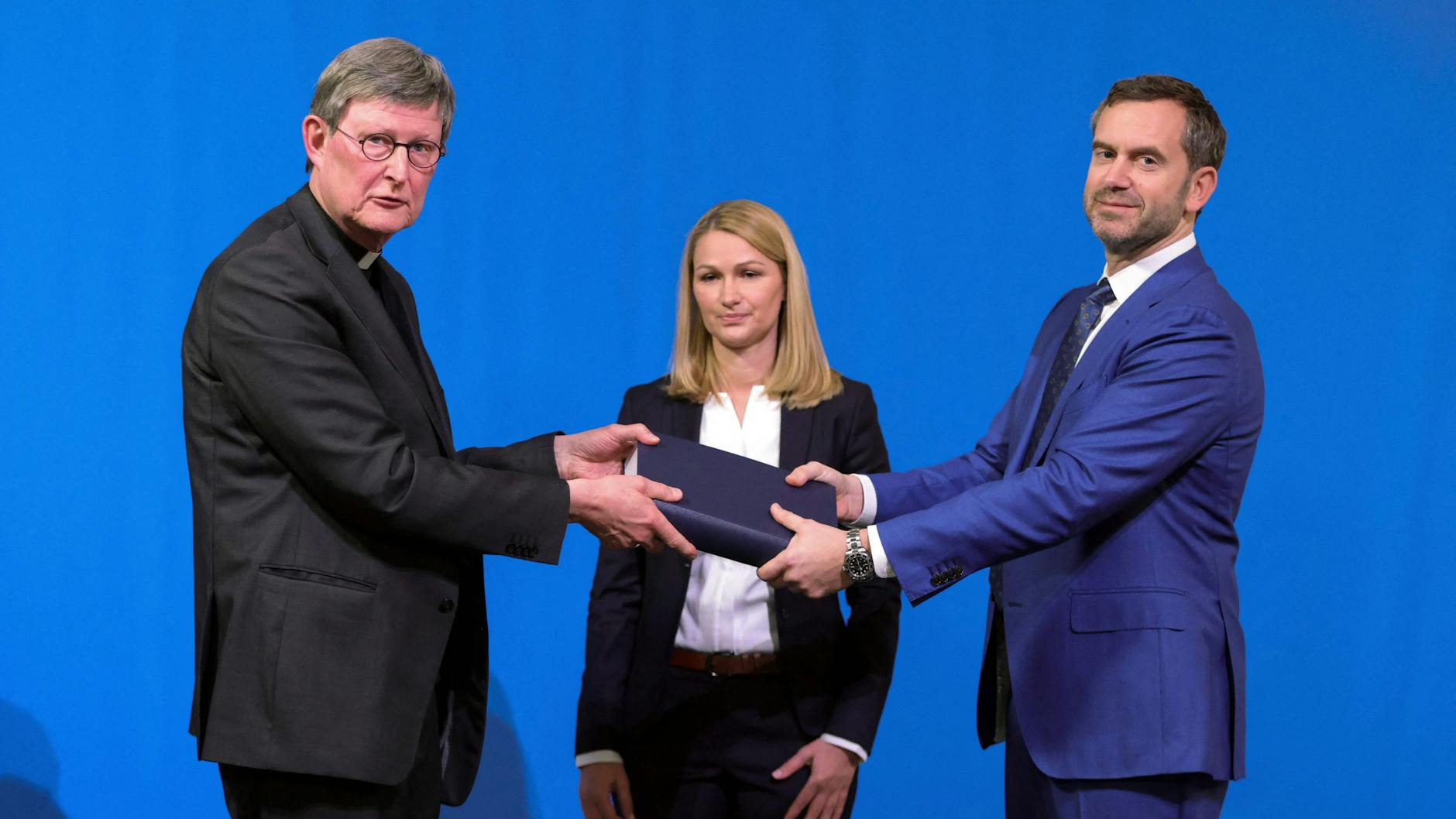 Kerstin Stirner und Björn Gercke überreichen den Missbrauchsbericht an Rainer Maria Kardinal Woelki (l.).