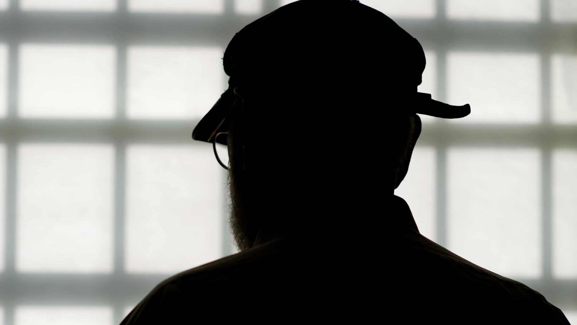 Im Alter von 84 Jahren steht Deutschlands ältester Häftling in der Justizvollzugsanstalt vor dem vergitterten Fenster eines Besucherraums. 