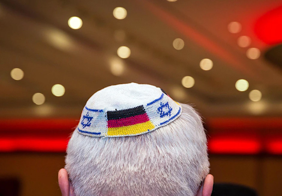 Ein Mann trägt eine Kippa mit eingearbeiteten israelischen und deutschen Fahnen
