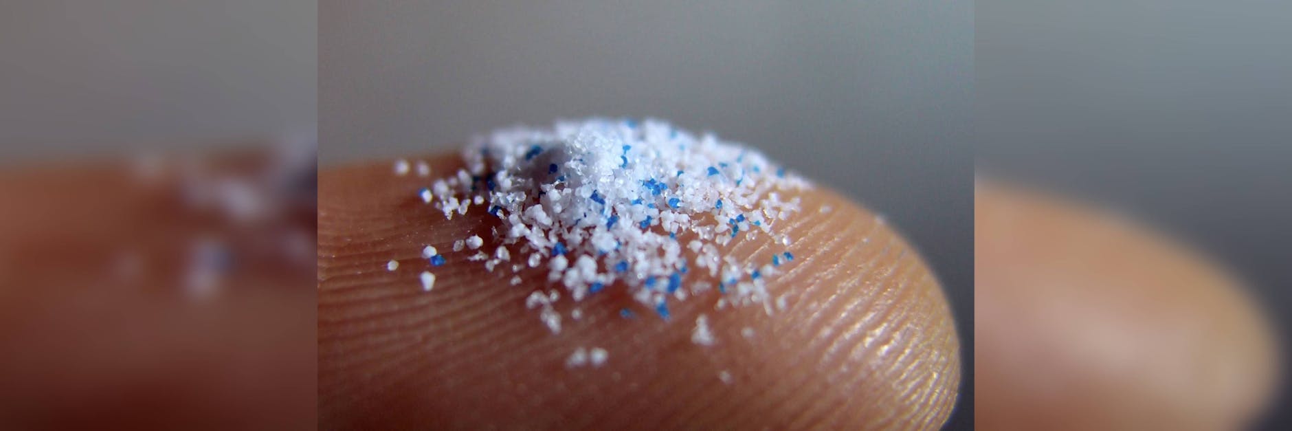 Mikroplastik auf einem Finger.