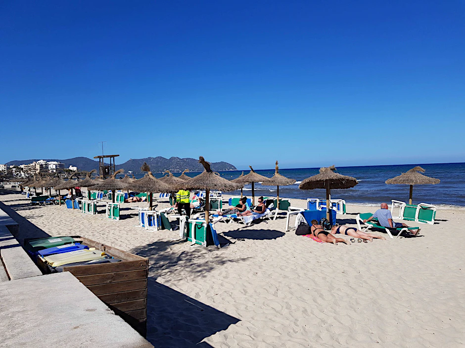 Touristen am Strand an der Paltja de Mallorca.